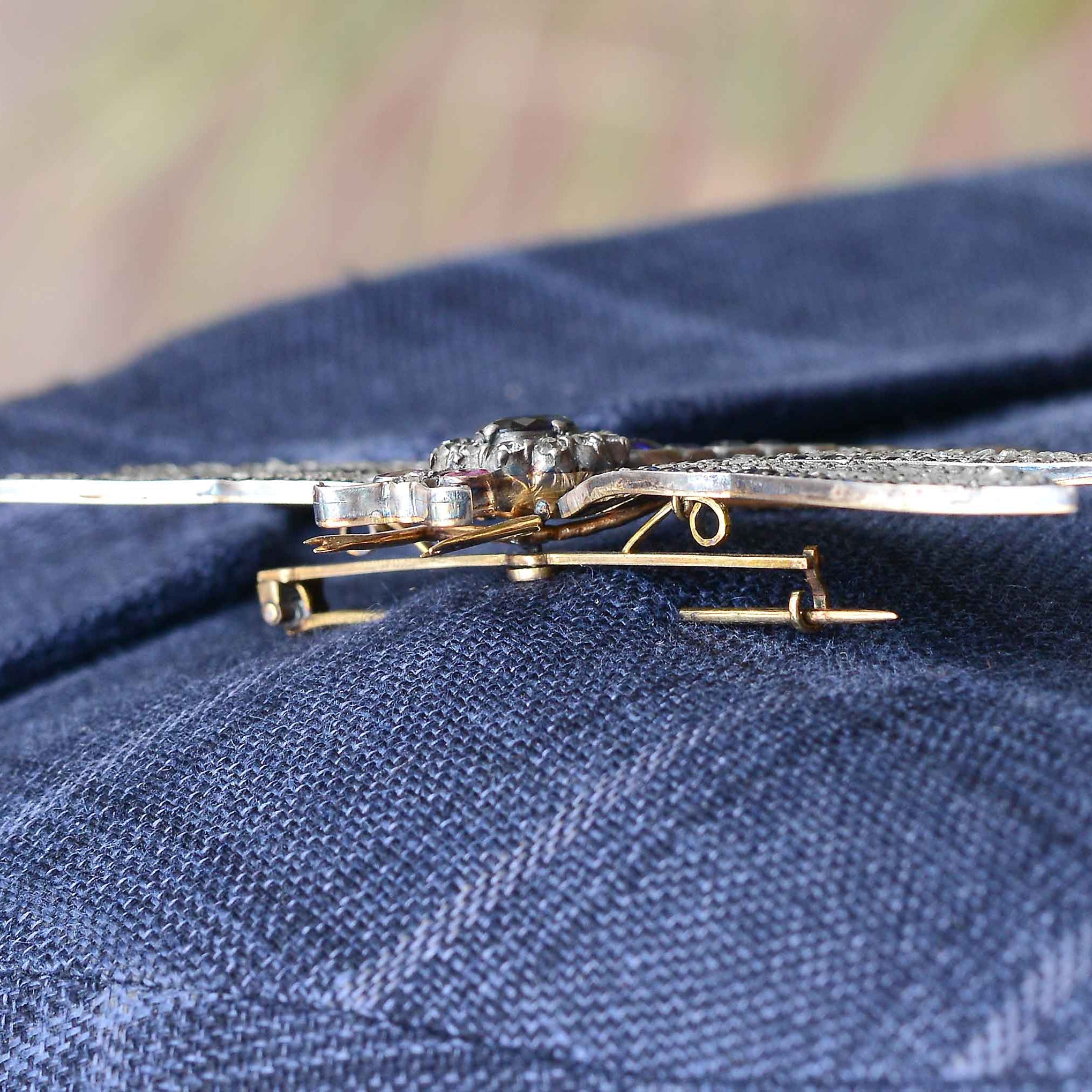 This Art Nouveau style dragonfly pin is securely attached to an adult sport coat.