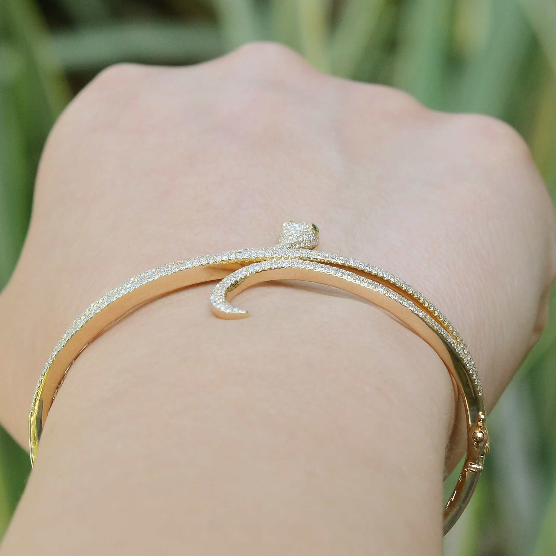A narrow modern bangle bracelet made of 14k yellow gold.