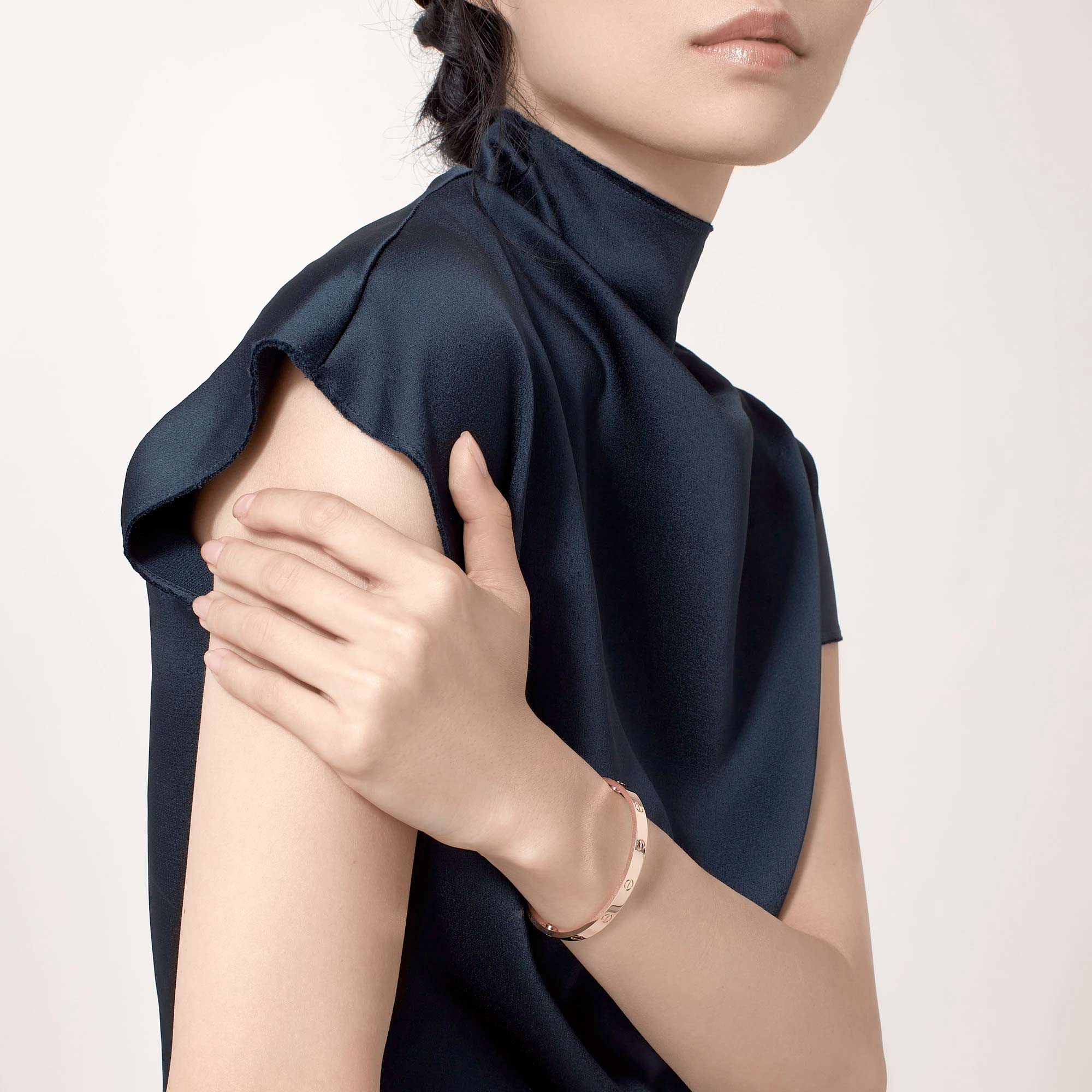 A stylish modern gold love bracelet by designer, Cartier.