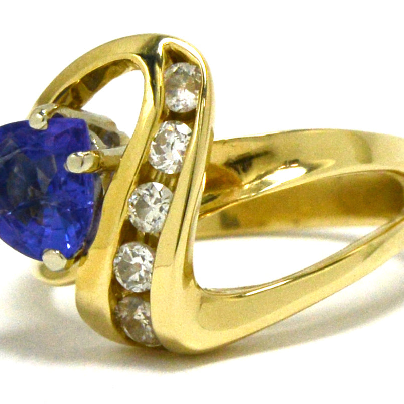 An asymmetrical 14k gold ring design with a trillion cut tanzanite.
