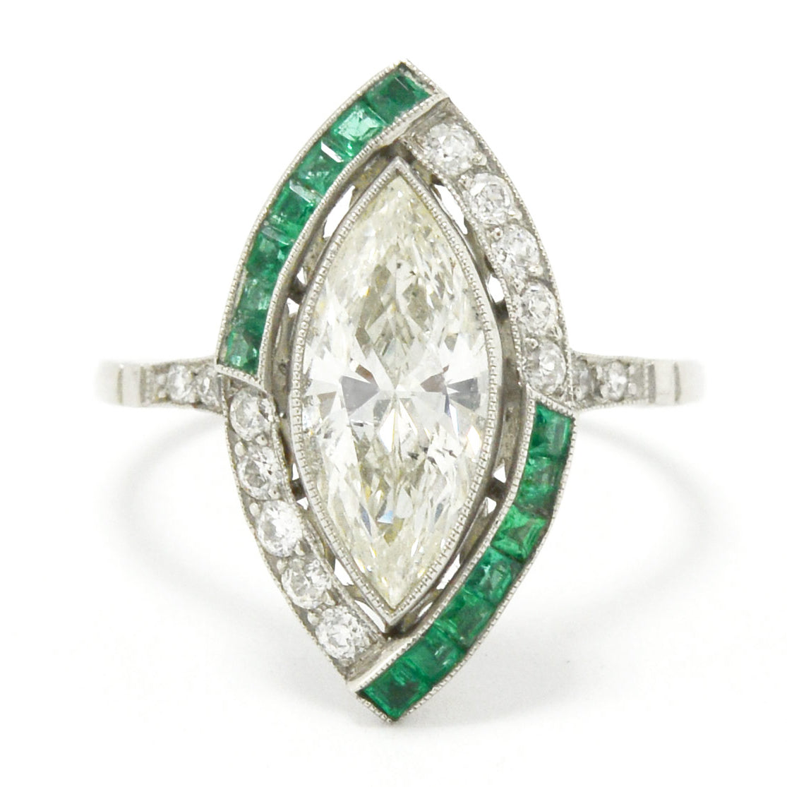 French cut emeralds accent the large marquise cut diamond in this platinum engagement ring.