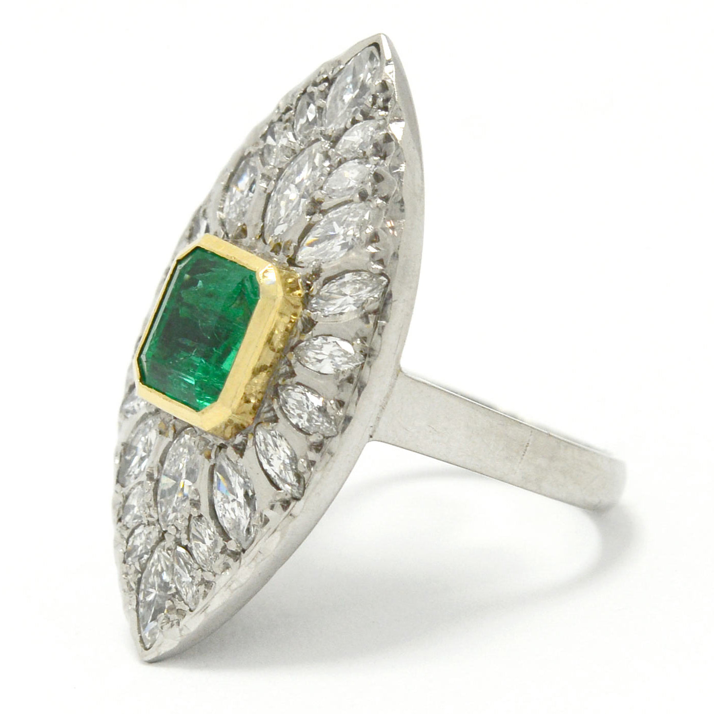 An 18k yellow gold bezel supports the two carat emerald in this stunning cluster statement ring.