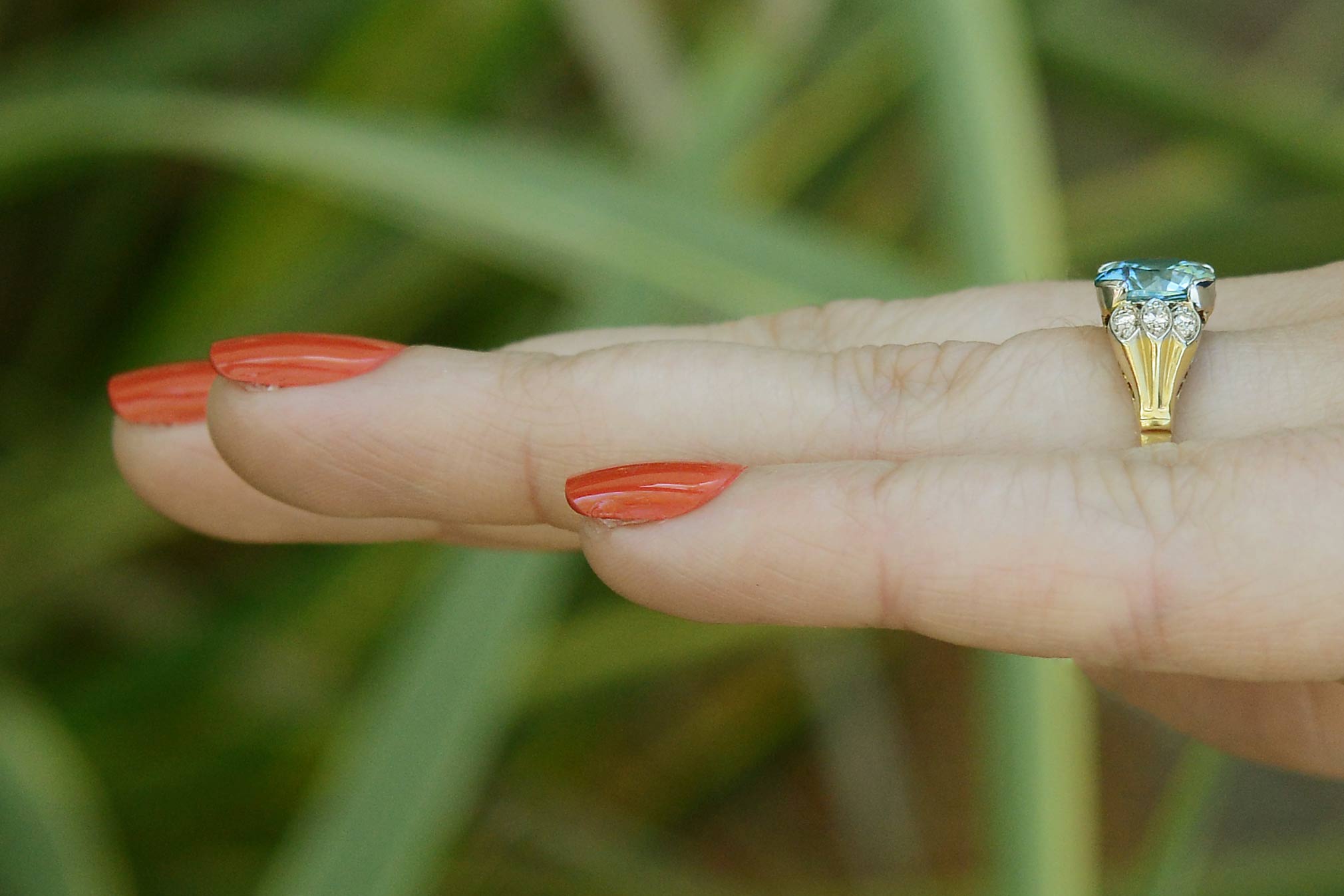A nearly 3 carat round zircon ring with three diamonds to each side of the gem.