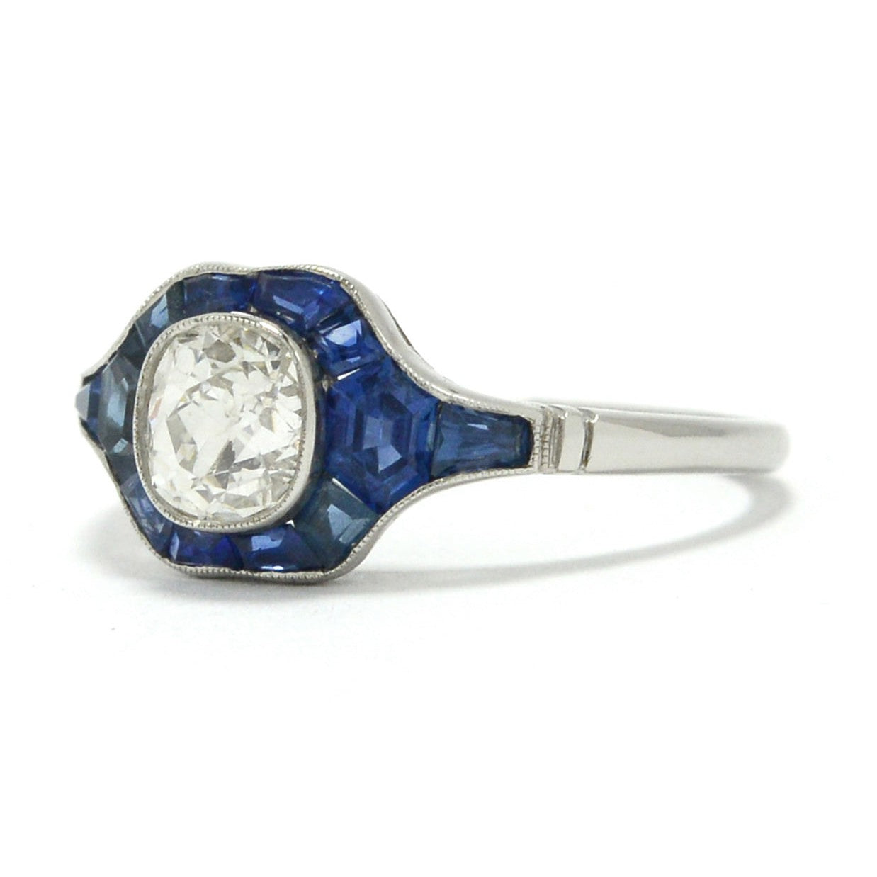 French and calibre cut sapphires accent this unique platinum and diamond engagement ring.