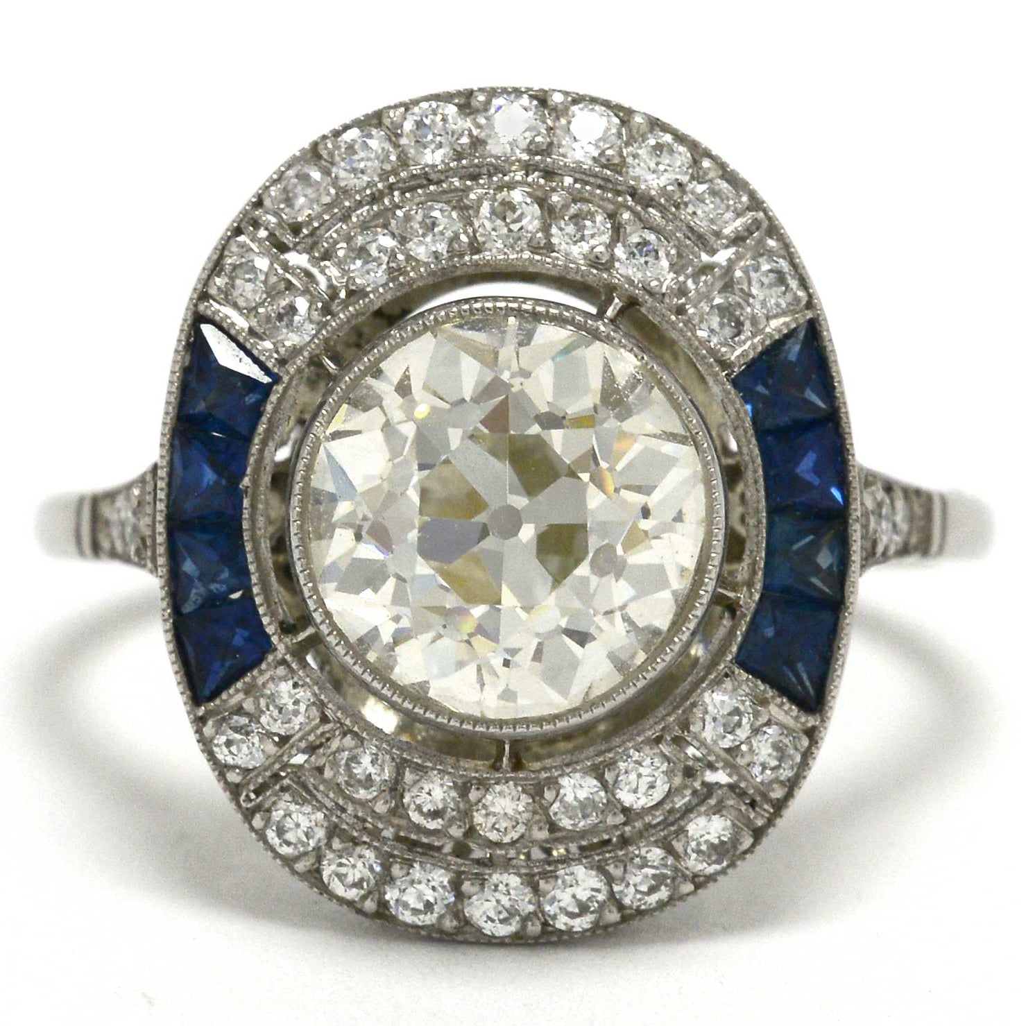 An old mine brilliant diamond cocktail ring with blue sapphire sides.