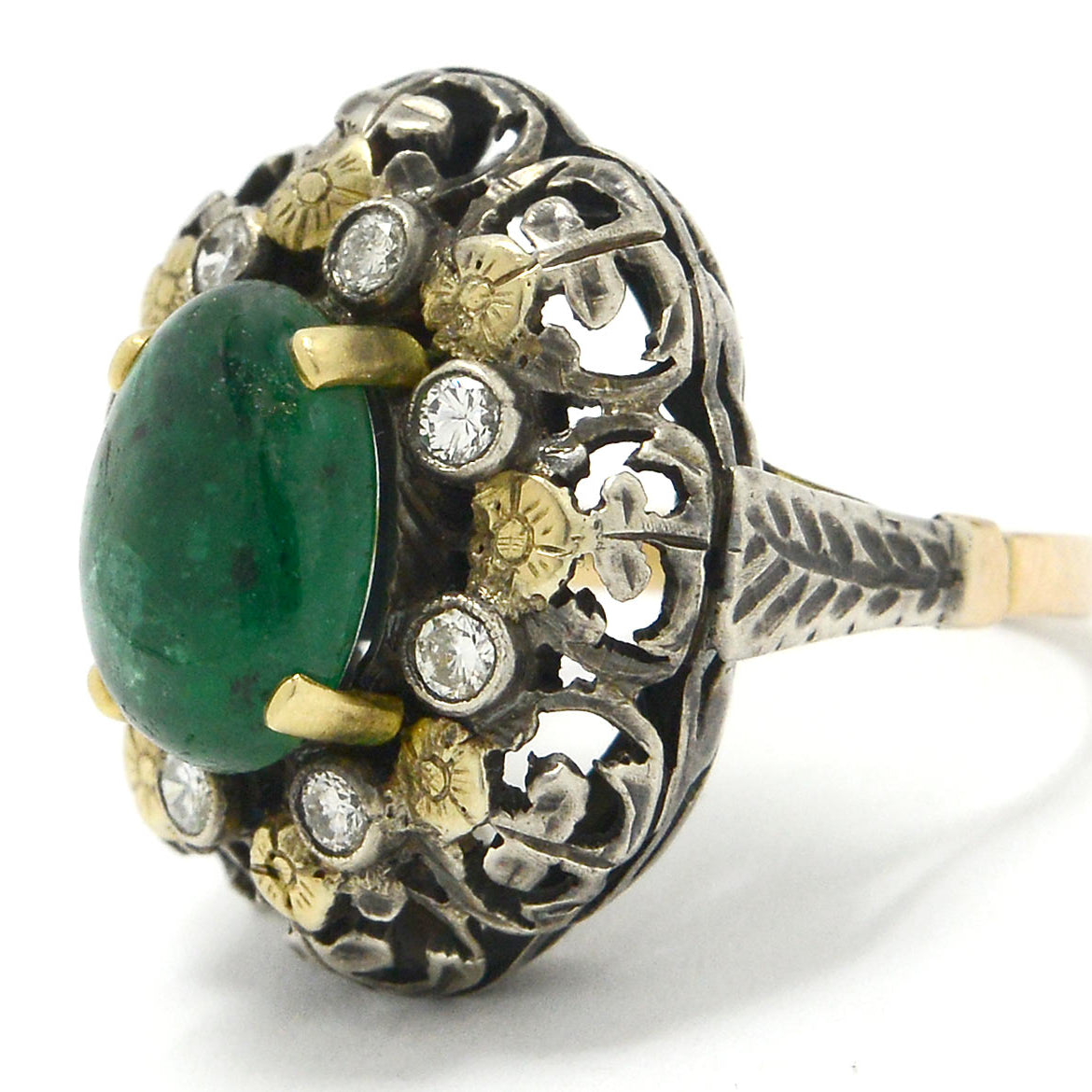 A floral, three carat emerald dome ring crafted of silver and gold.