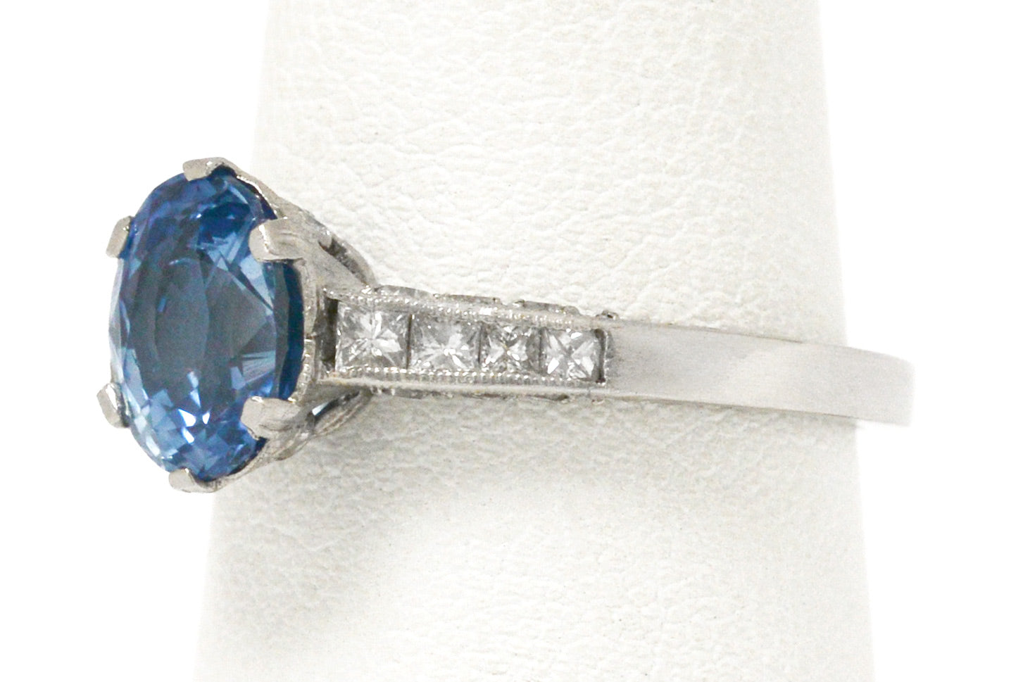 8 diamonds support the ceylon blue sapphire in this platinum vintage engagement ring.