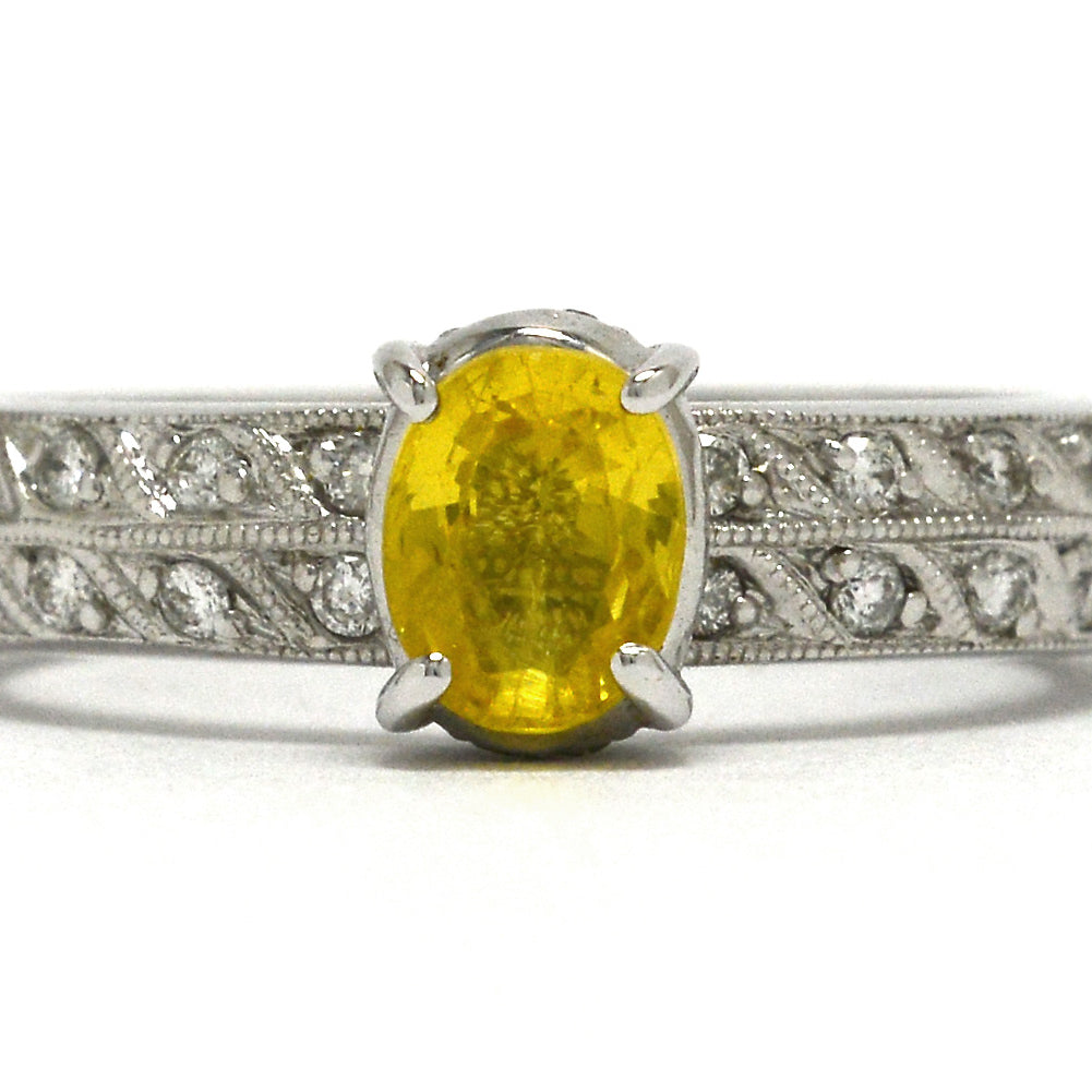 1 carat oval faceted yellow sapphire wedding ring with 2 rows of diamonds on the band.