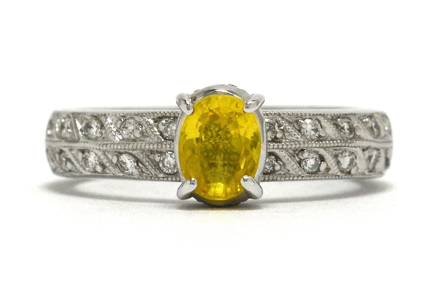 1 carat oval faceted yellow sapphire wedding ring with 2 rows of diamonds on the band.