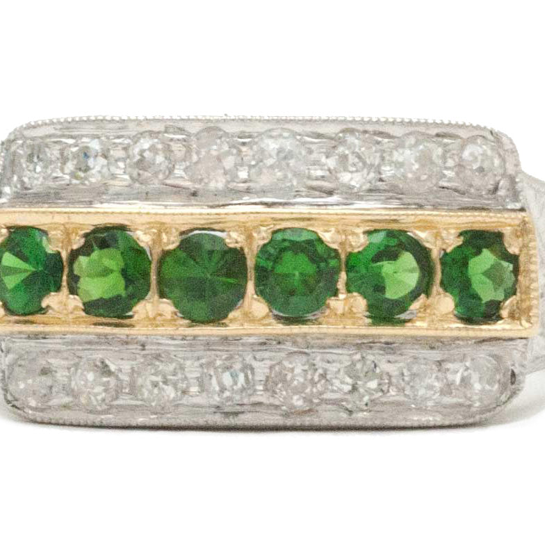 A gold and palladium, 2 tone wedding band with green tsavorite gems.