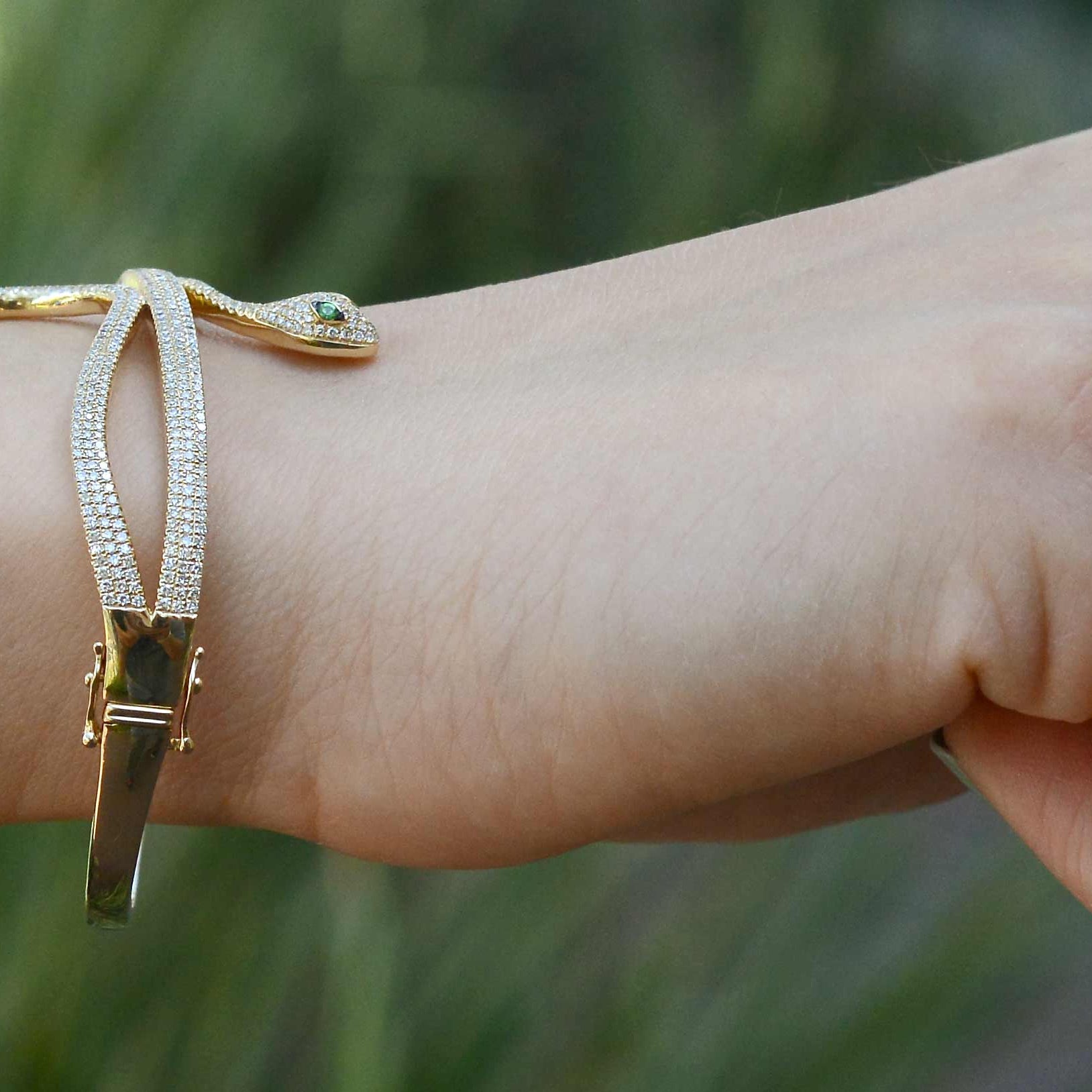 A modern gold snake bracelet with 2 safety clasps.