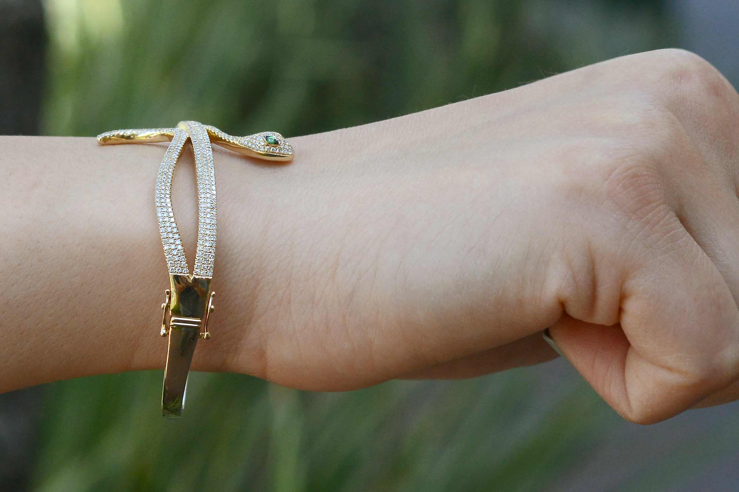 A modern gold snake bracelet with 2 safety clasps.