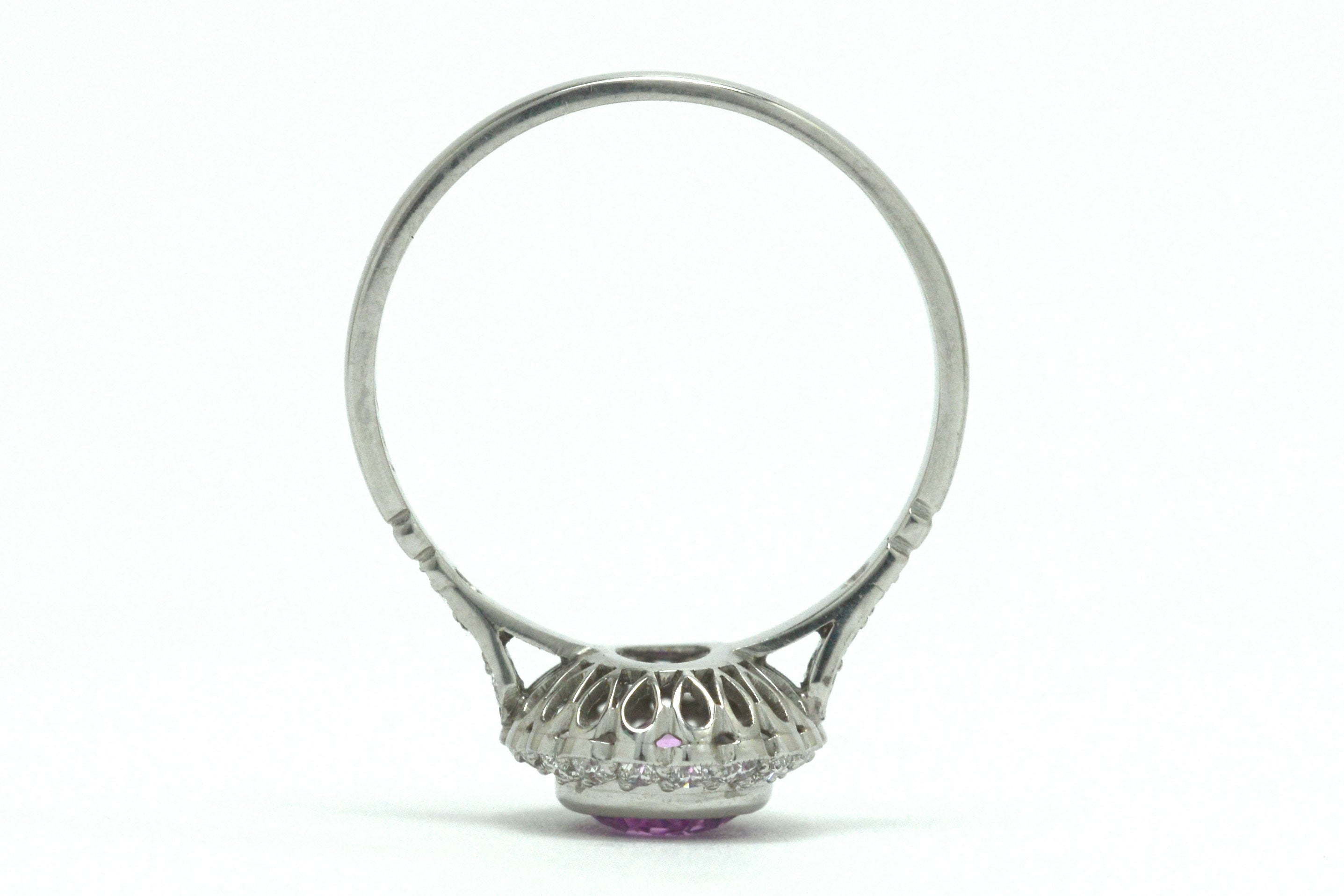 A platinum foliate scrolled under-crown engagement ring.