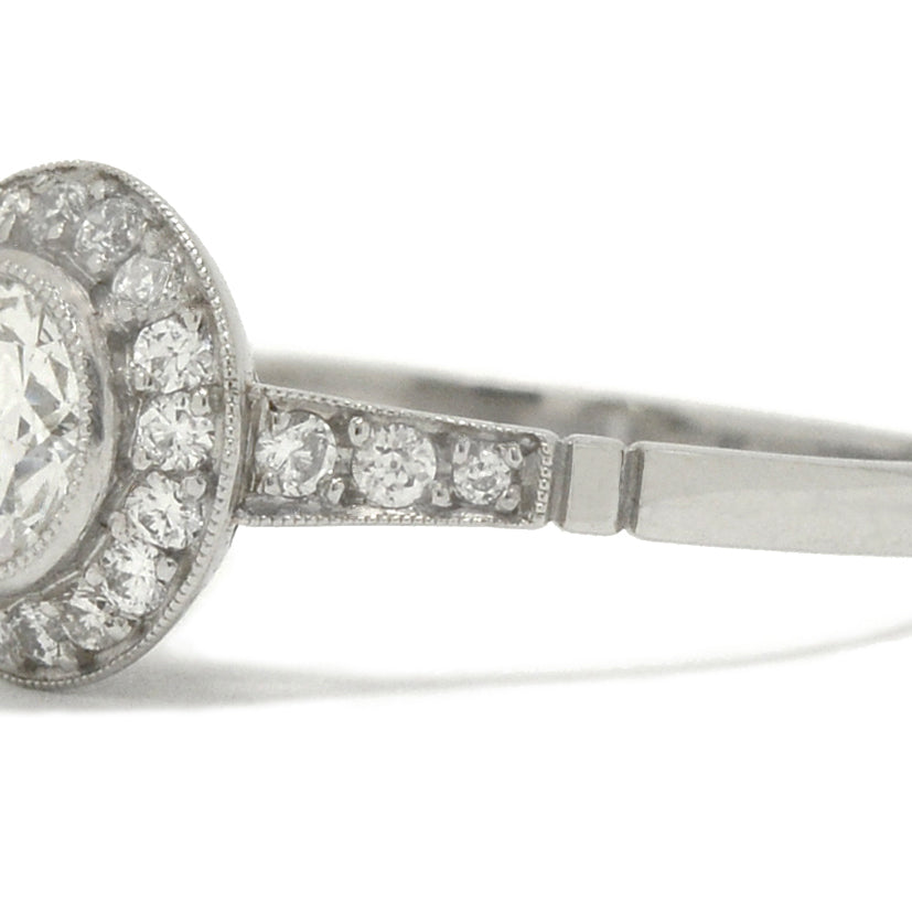 A round, old European diamond is surrounded by a halo in this engagement ring.
