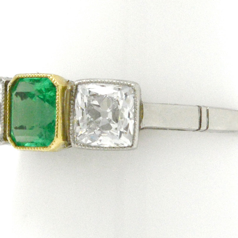 An early 1900s Art Deco emerald and diamond three stone ring design.