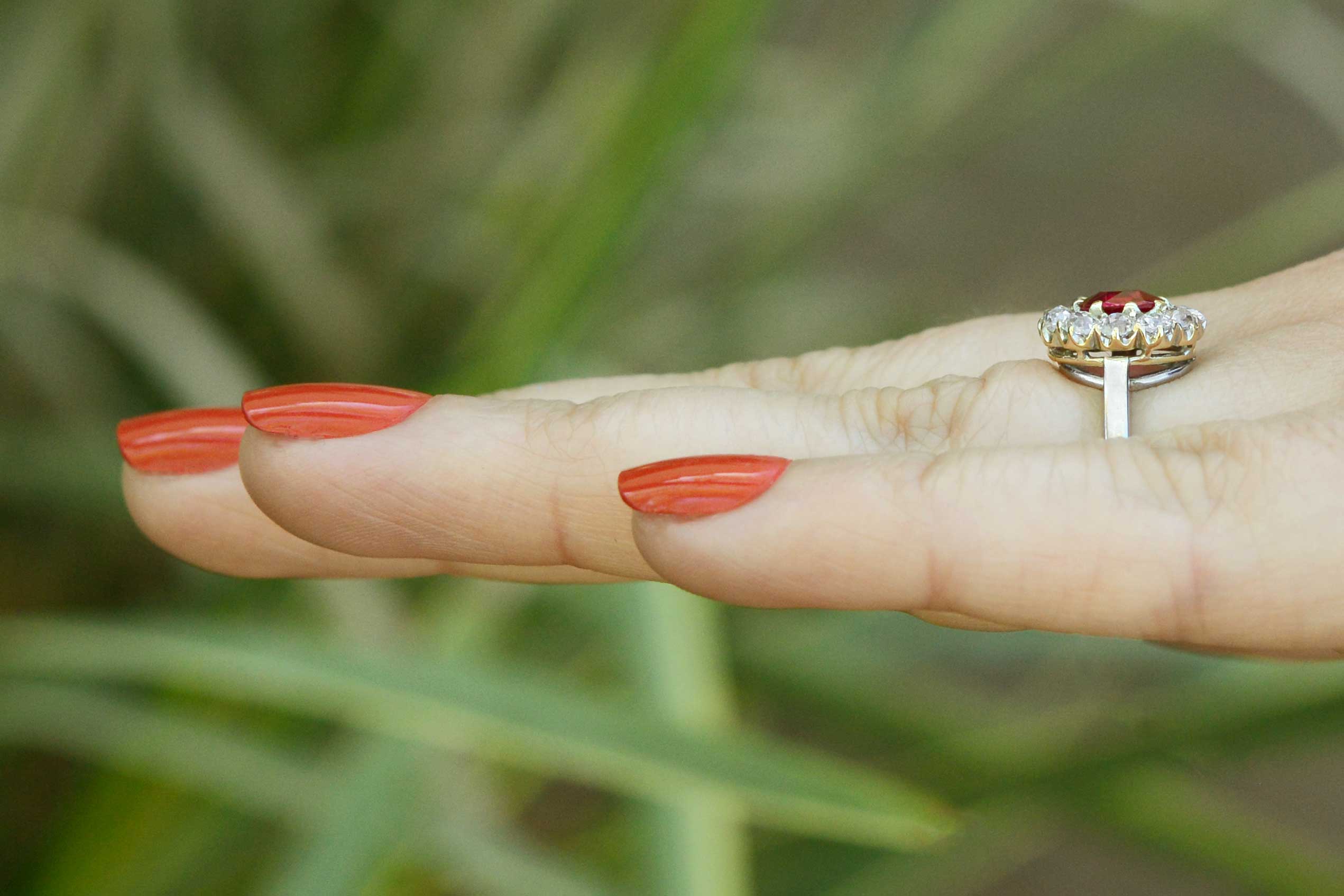 11 old mine cut diamonds encircle the bright red antique cushion cut ruby.