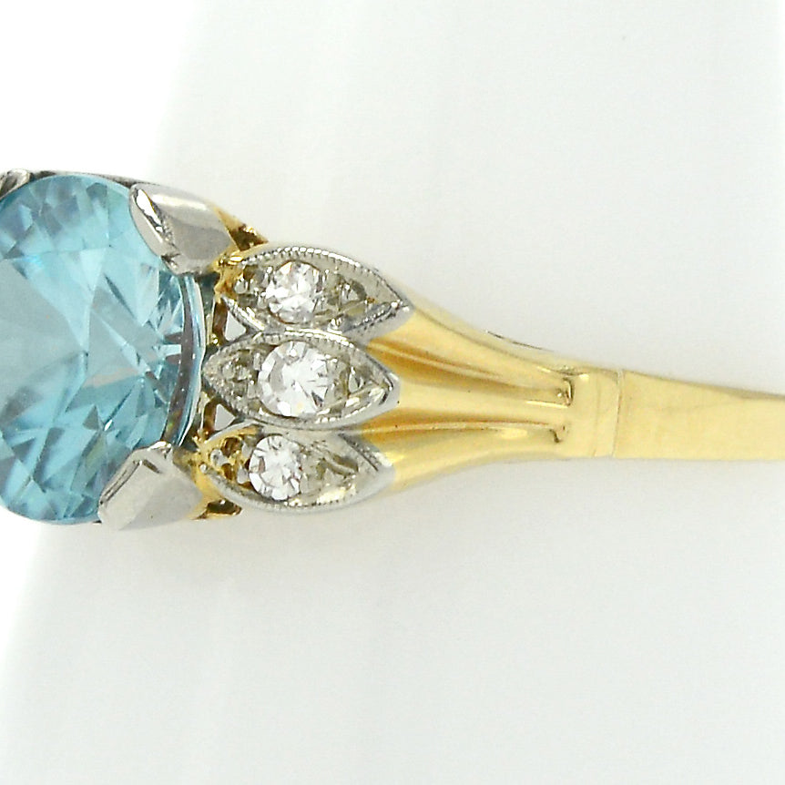 A radiating 18k gold band supporting a neon blue zircon.