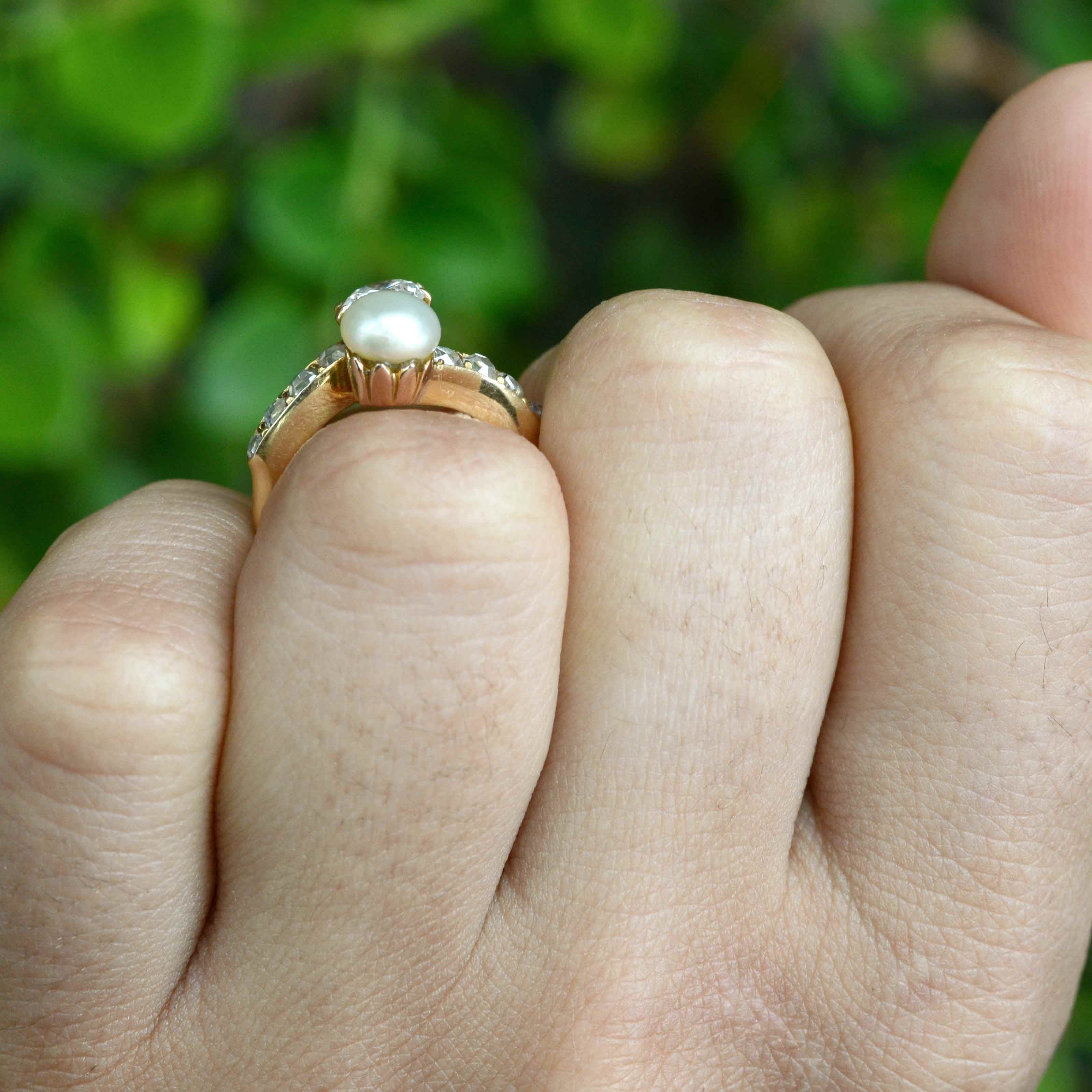 This gold solitaire ring features a pearl and diamonds.