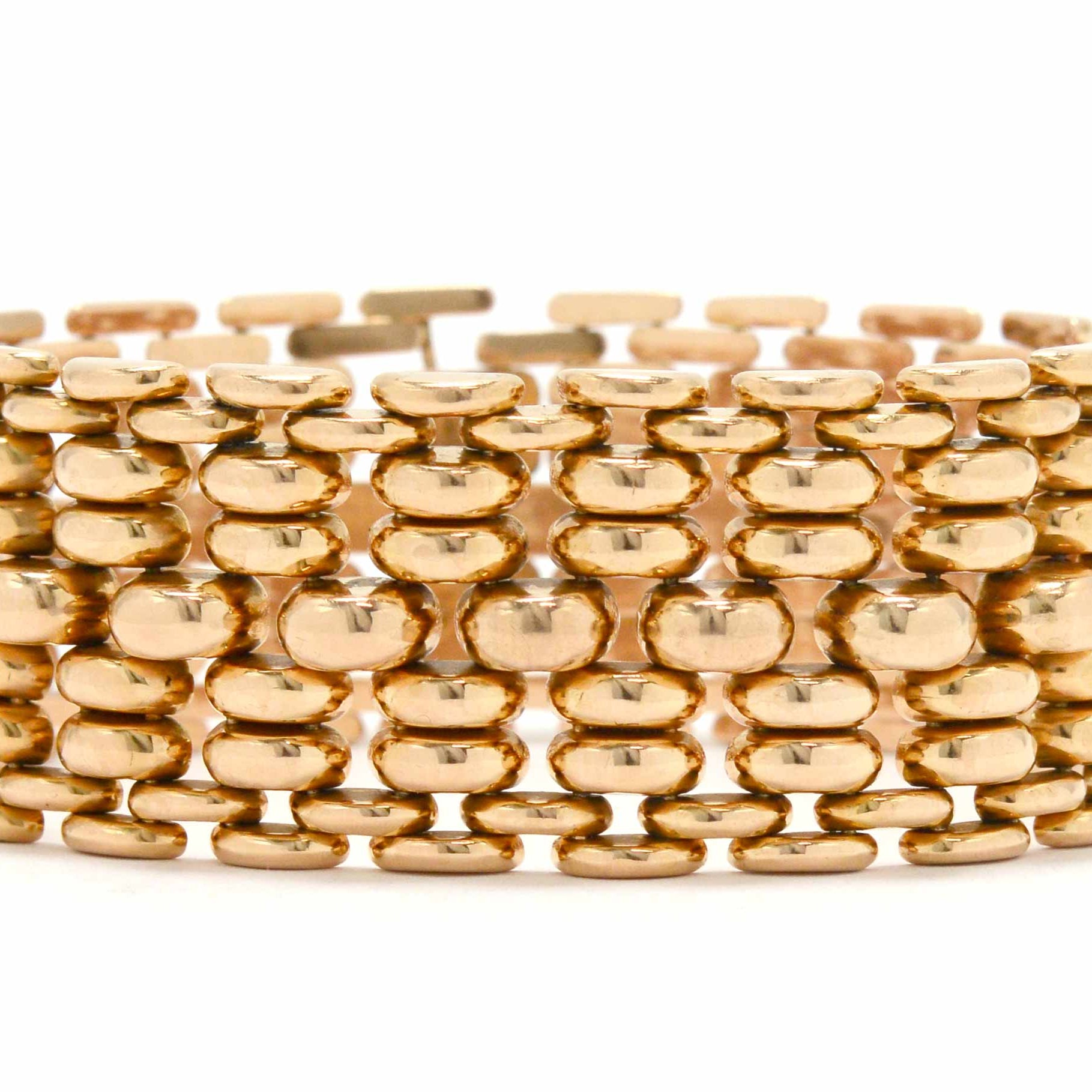An iconic rose gold woven link bracelet styled after WWII era tank treads.