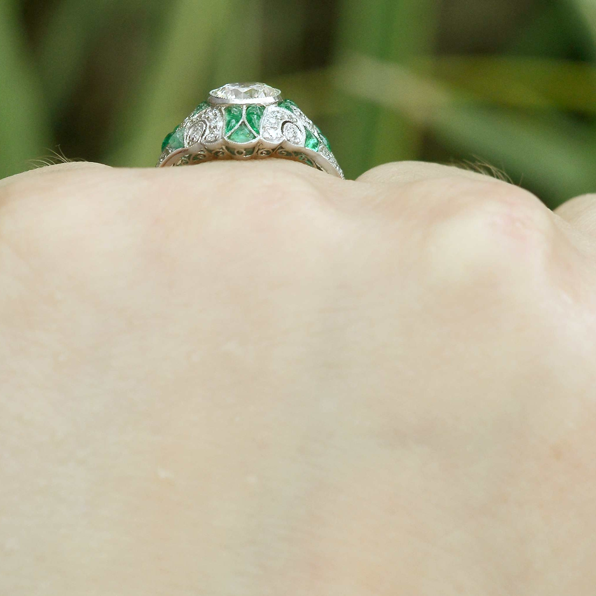 Cabochon cut emeralds line this diamond mosaic engagement ring.