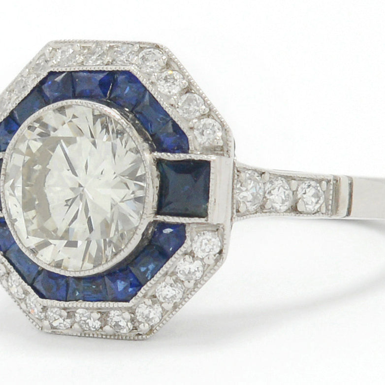 A 2 carat round brilliant diamond octagon engagement ring with a halo of sapphires.