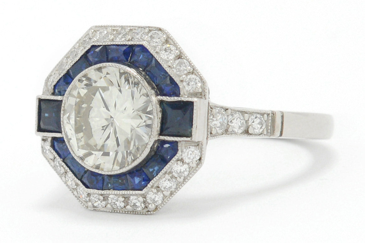 A 2 carat round brilliant diamond octagon engagement ring with a halo of sapphires.