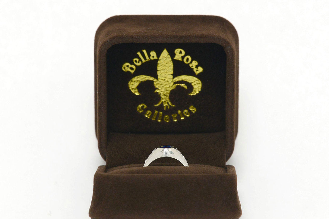 A platinum, dome setting sapphire ring with 6 diamonds.