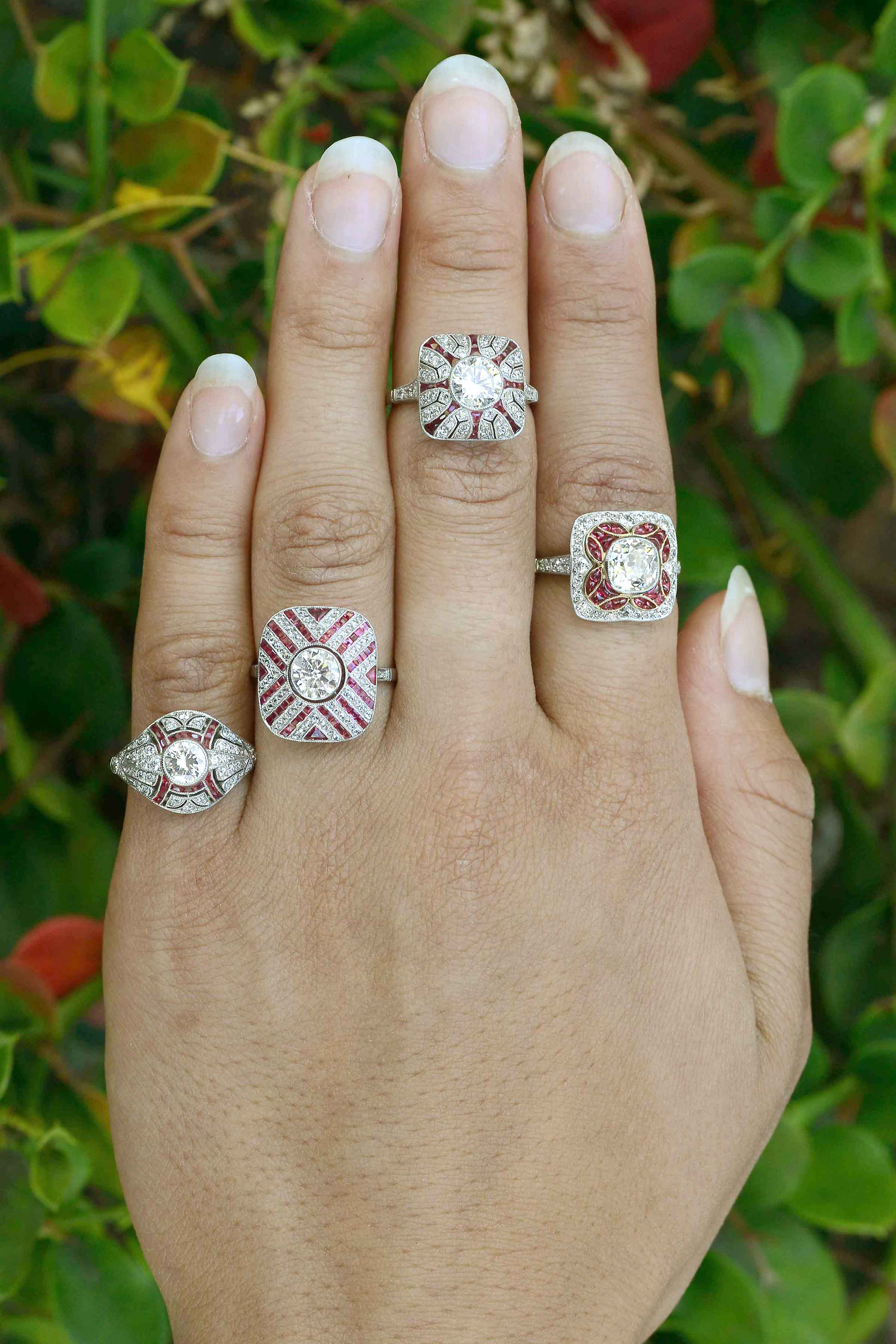 A collection of diamond with ruby accent, platinum engagement rings.
