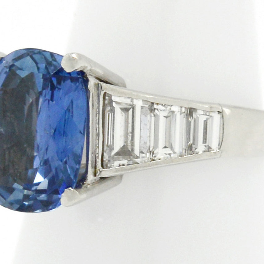 An unheated large oval ceylon sapphire engagement ring with 6 diamonds on the band.