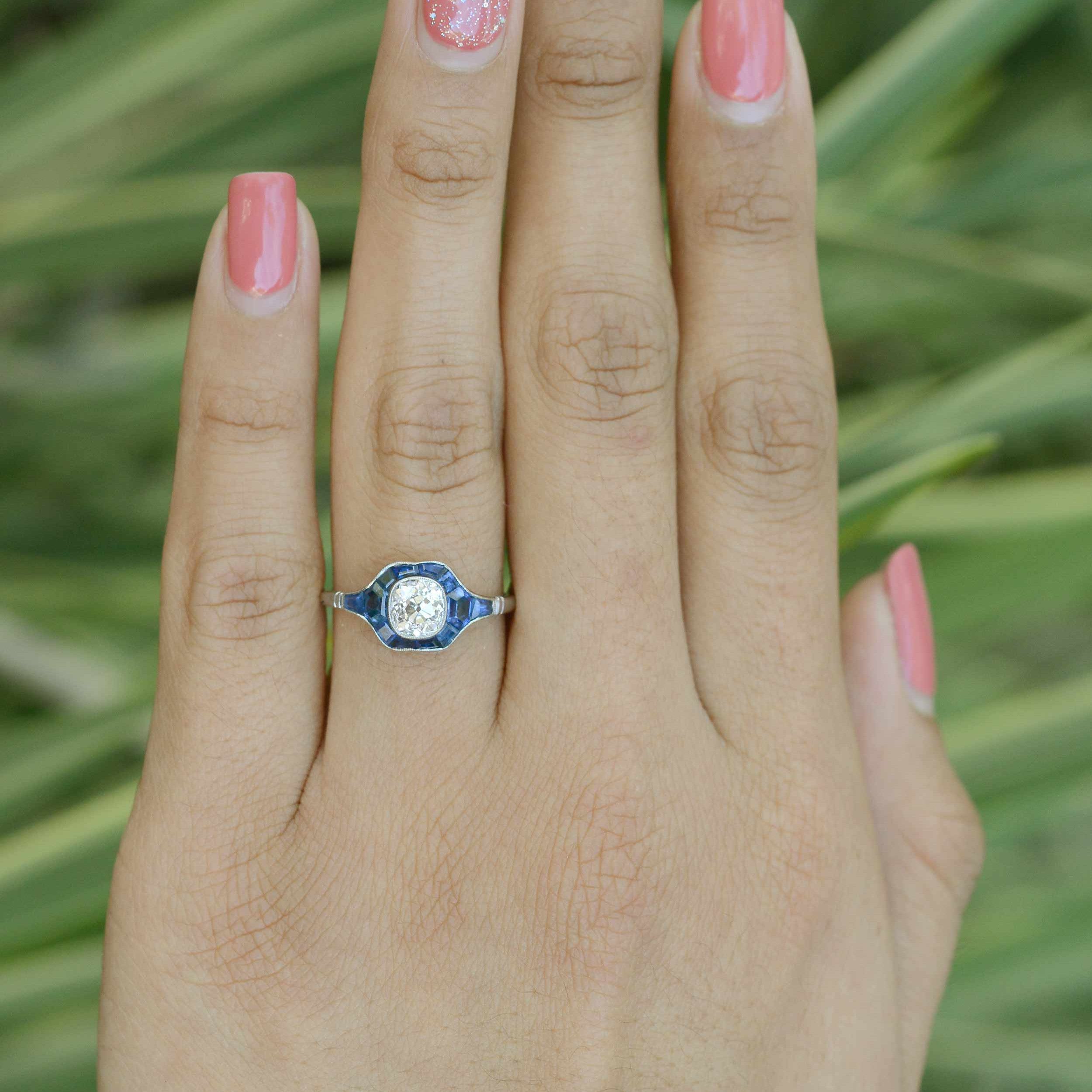 This diamond and blue sapphire bridal ring has a milgrain bezel setting.