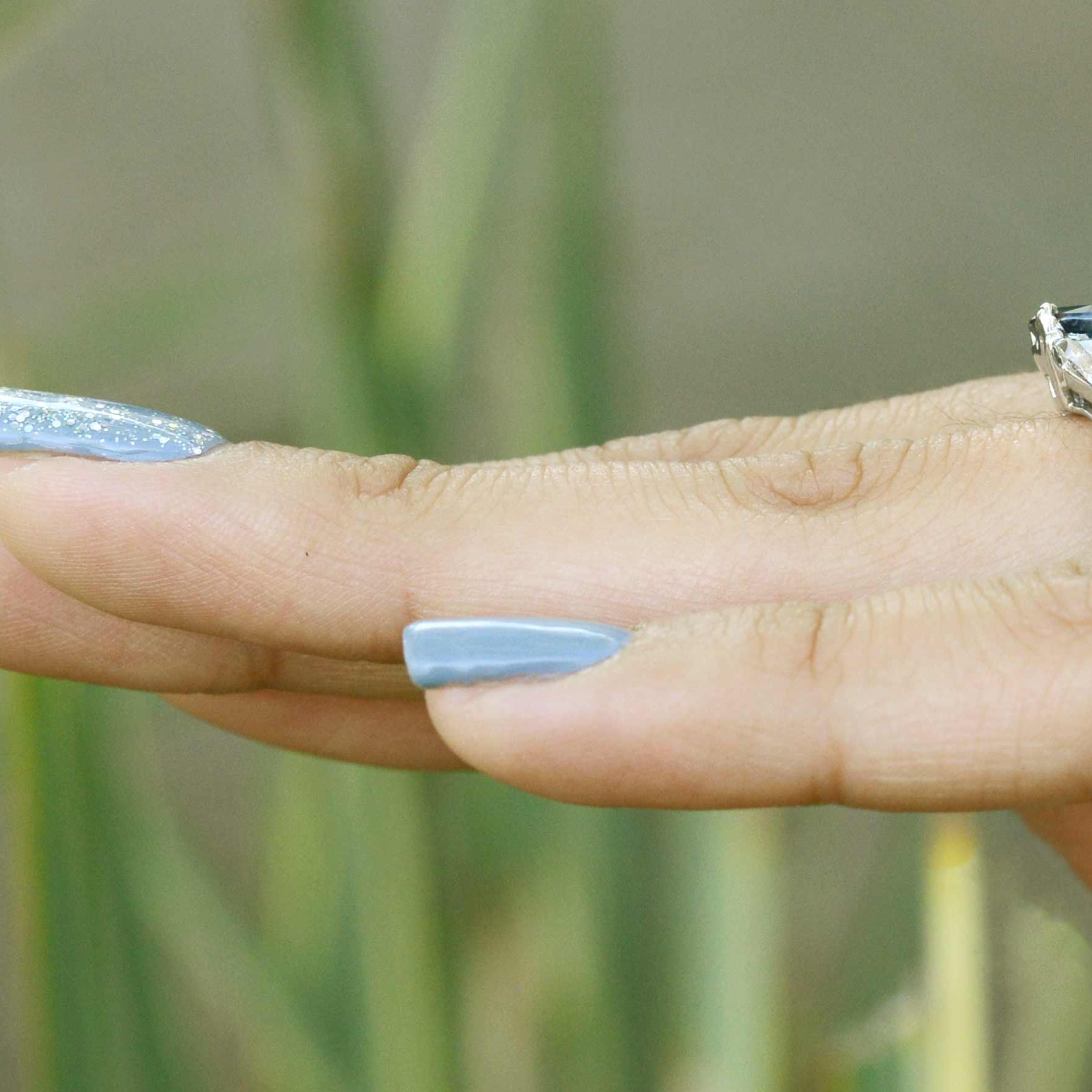 A 14k white gold blue sapphire ring with 2 diamonds.