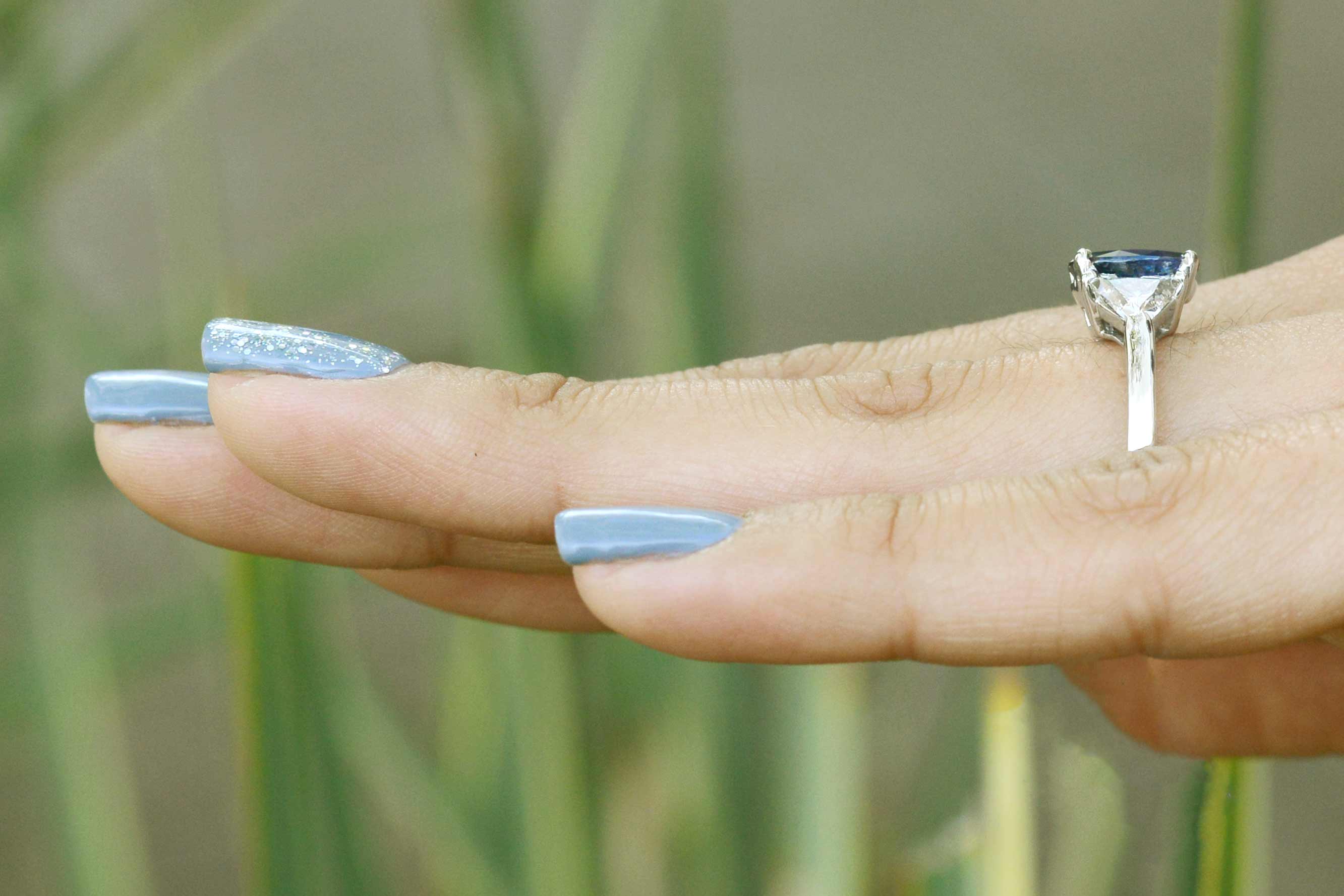 A 14k white gold blue sapphire ring with 2 diamonds.