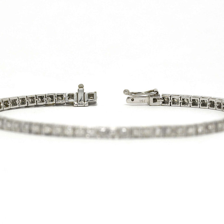 A slide lock and safety clasp keeps this white gold tennis bracelet secure.