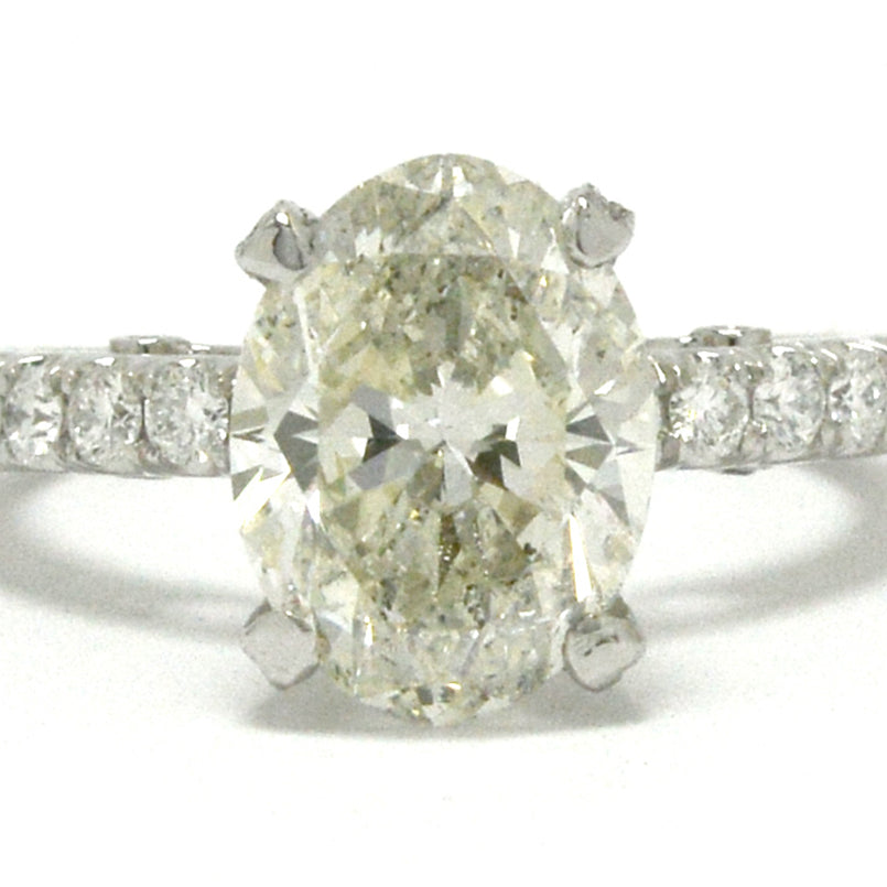 A large oval 3 carat diamond is set in a solitaire engagement ring setting.