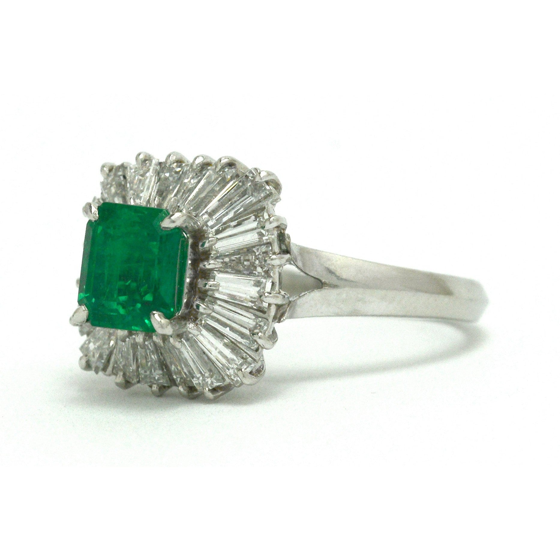 A platinum emerald ballerina ring, called that for its radiated design of diamonds halo.