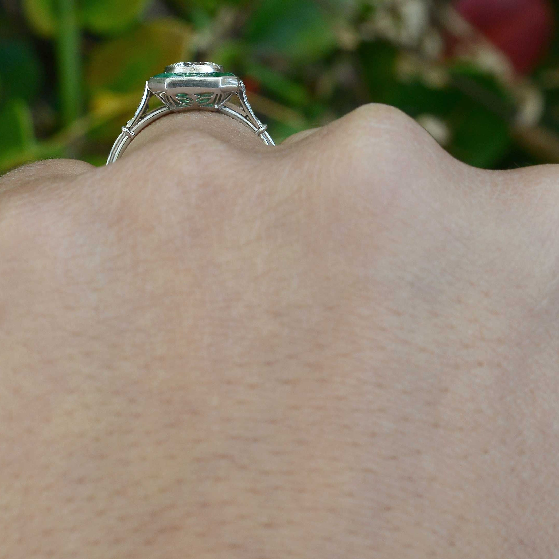 An Art Deco style diamonds emeralds engagement ring.