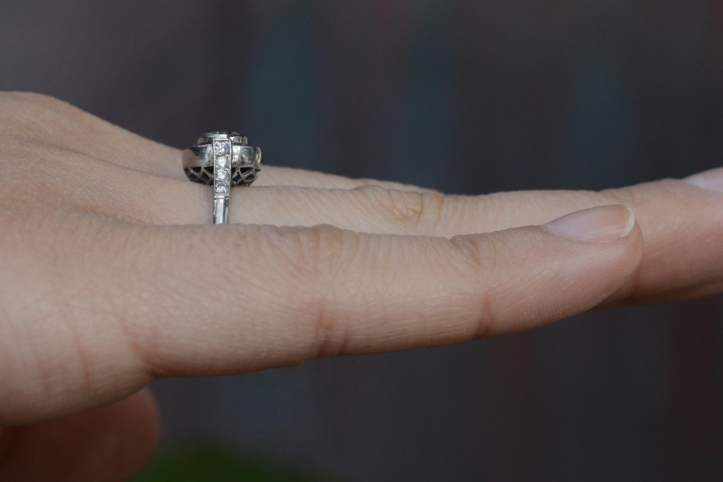 This ruby halo bridal ring has diamonds lined on the shoulder of the band.