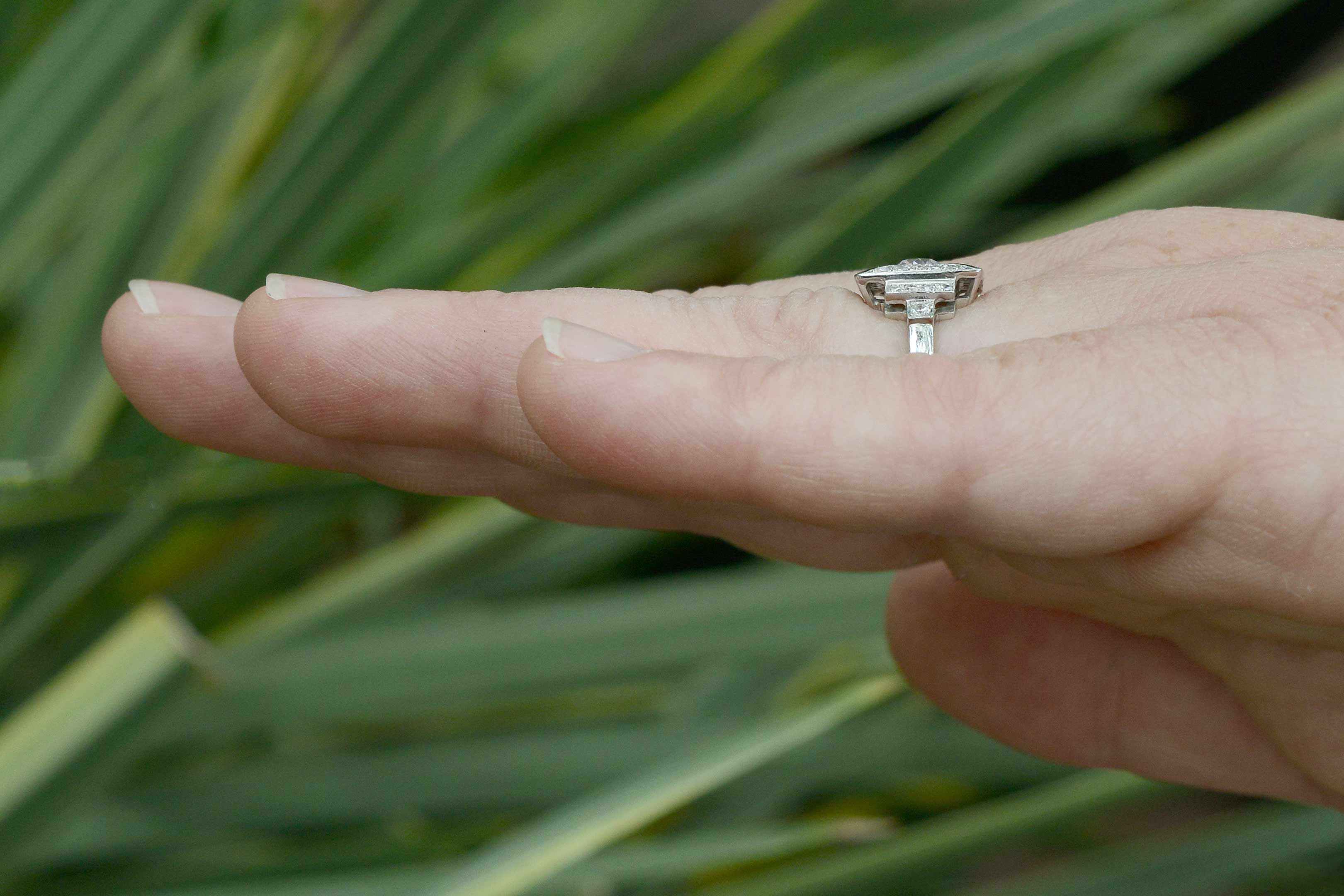 A tier design on the shoulders of this diamond engagement ring lined with black enamel.