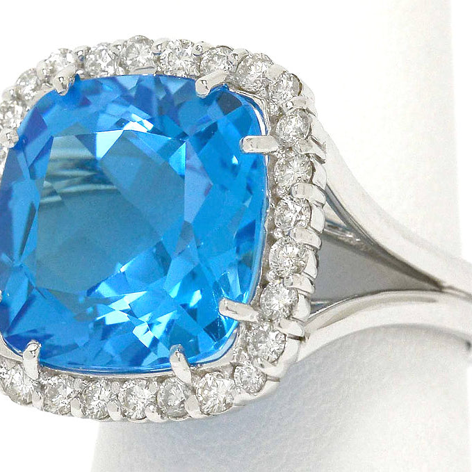 A large, 14 carat blue topaz cocktail ring with a square halo of diamonds.