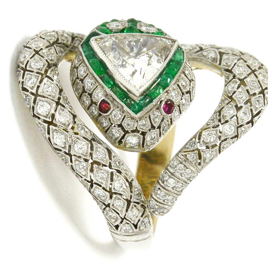 A platinum diamond snake ring with ruby eyes, emeralds surround the trillion cut diamond.