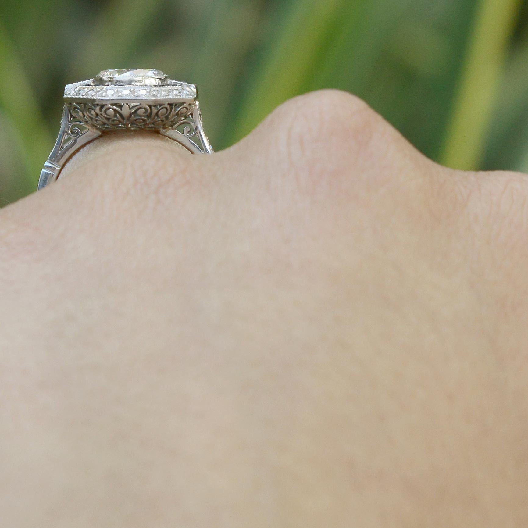 Fleur di lis filigree is shown on the underside of this stunning engagement ring.