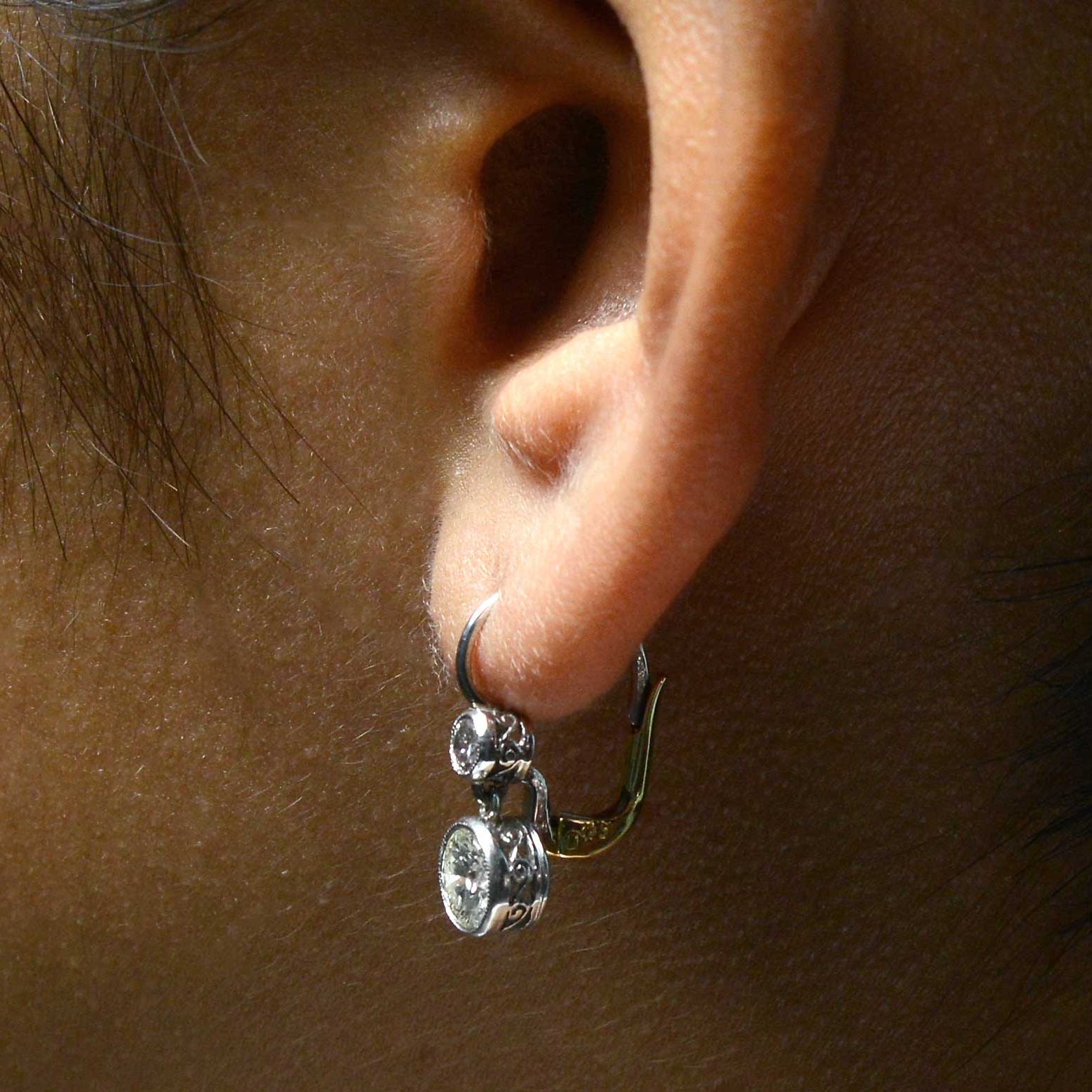 Two round brilliant diamonds dangle in these Victorian style lever back earrings.