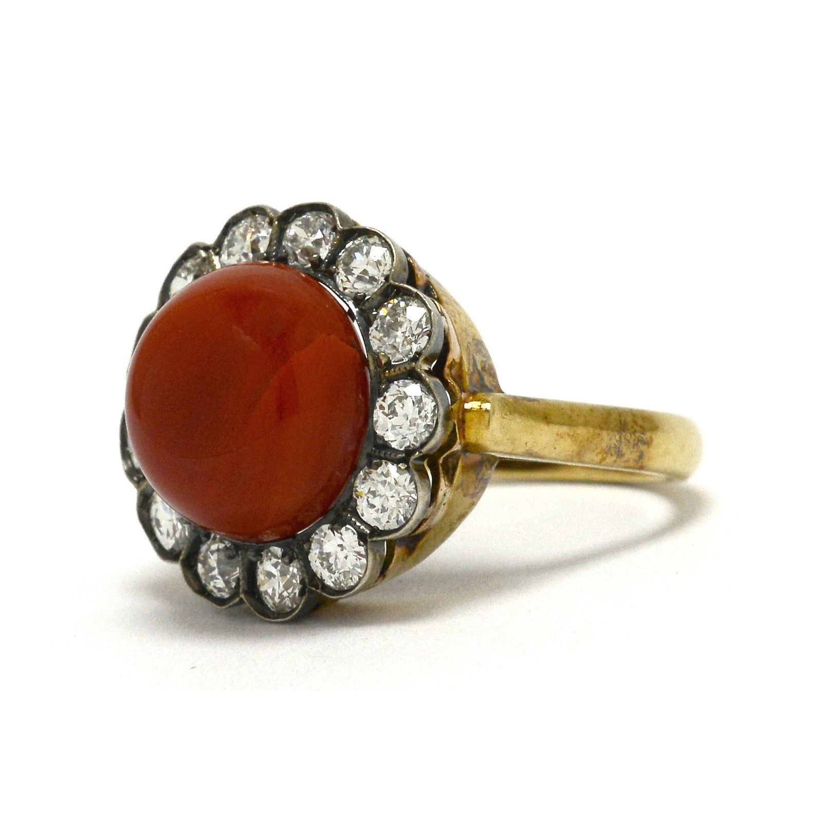 An antique, Victorian coral ring with a halo of diamonds.