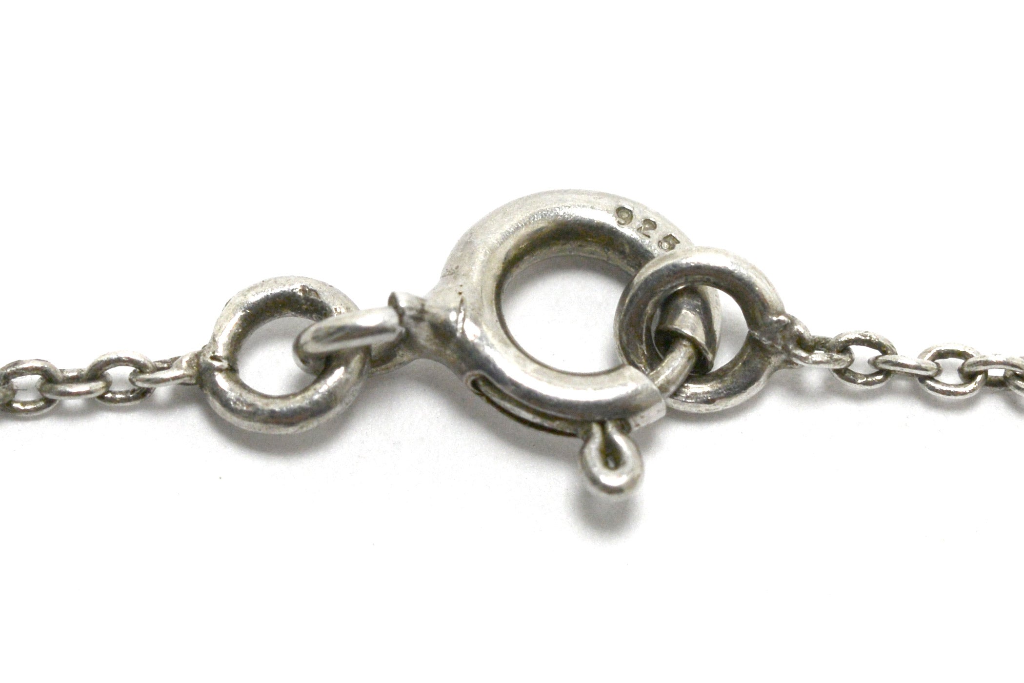 A spring ring fastens the chain holding the opal necklace.