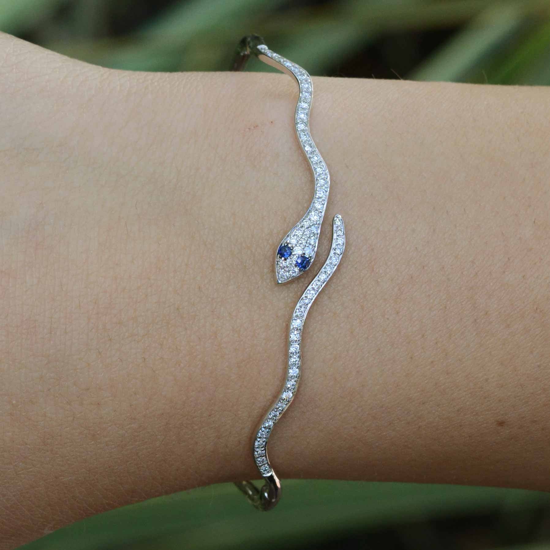 A white gold modern snake bracelet with sapphire eyes.