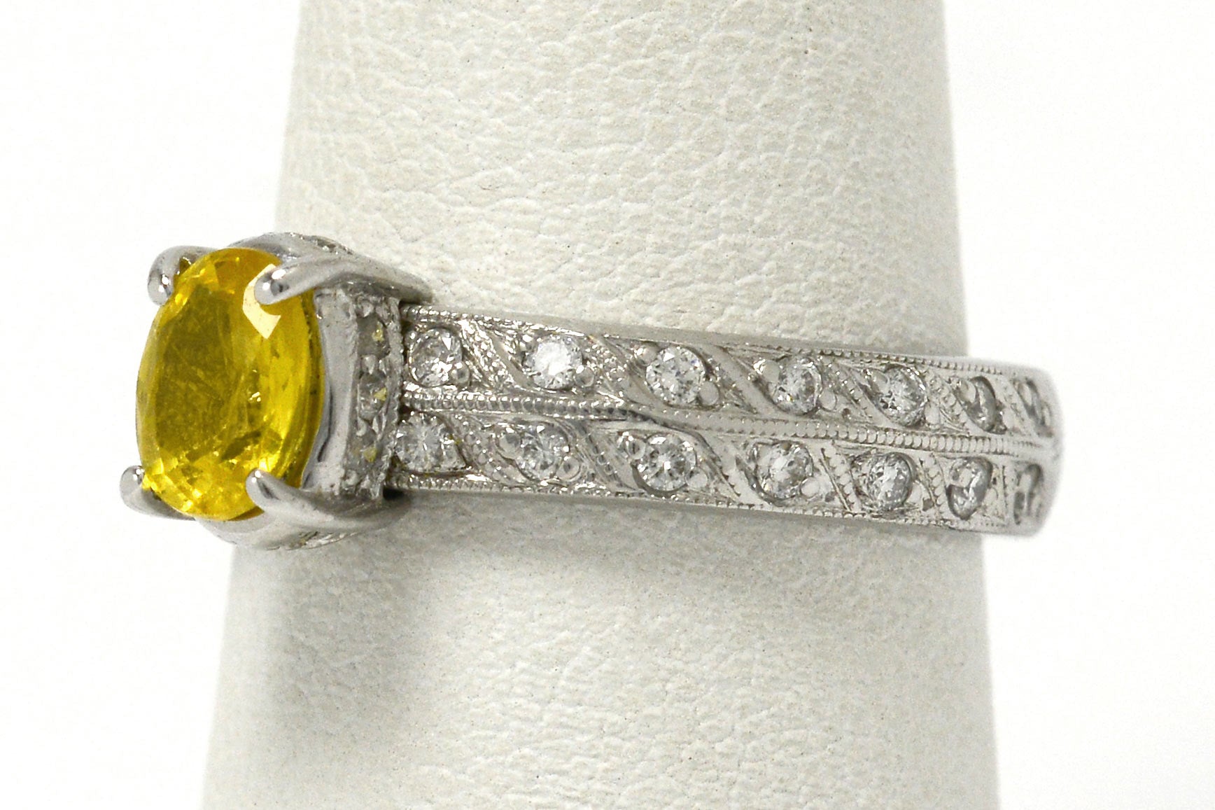 At nearly 1 carat, this golden yellow sapphire is secured by 4 prongs in this band.