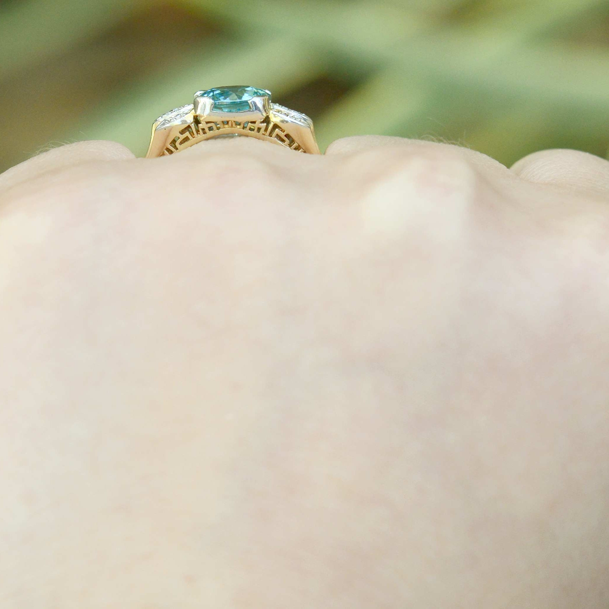 A neon blue zircon with great clarity set in a bridal ring with diamonds.
