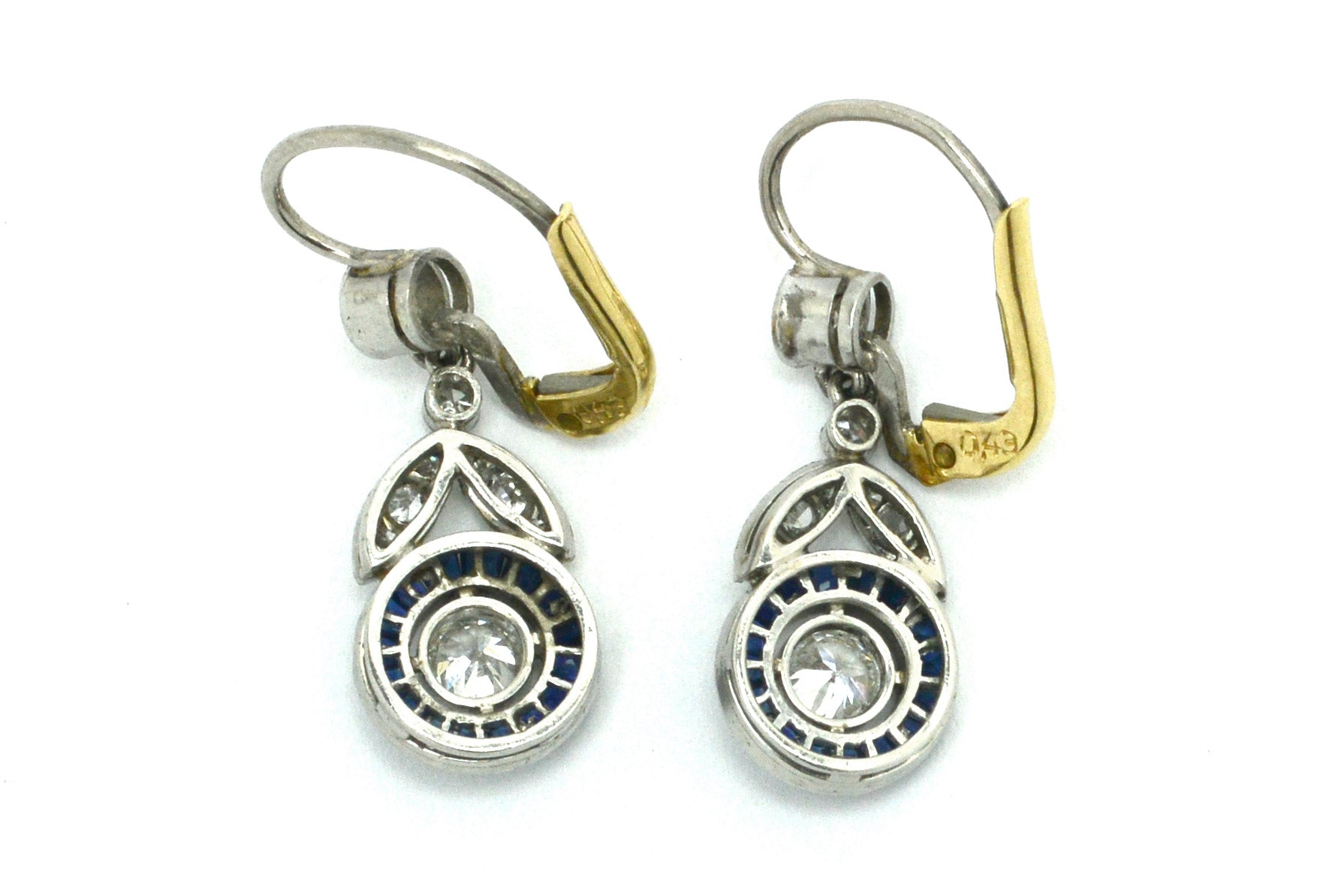 The finely detailed milgrain bezel and the calibre' and French cut halo of blue sapphires.