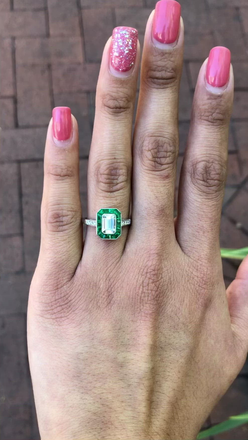 An Art Deco style emeralds and diamonds wedding ring.