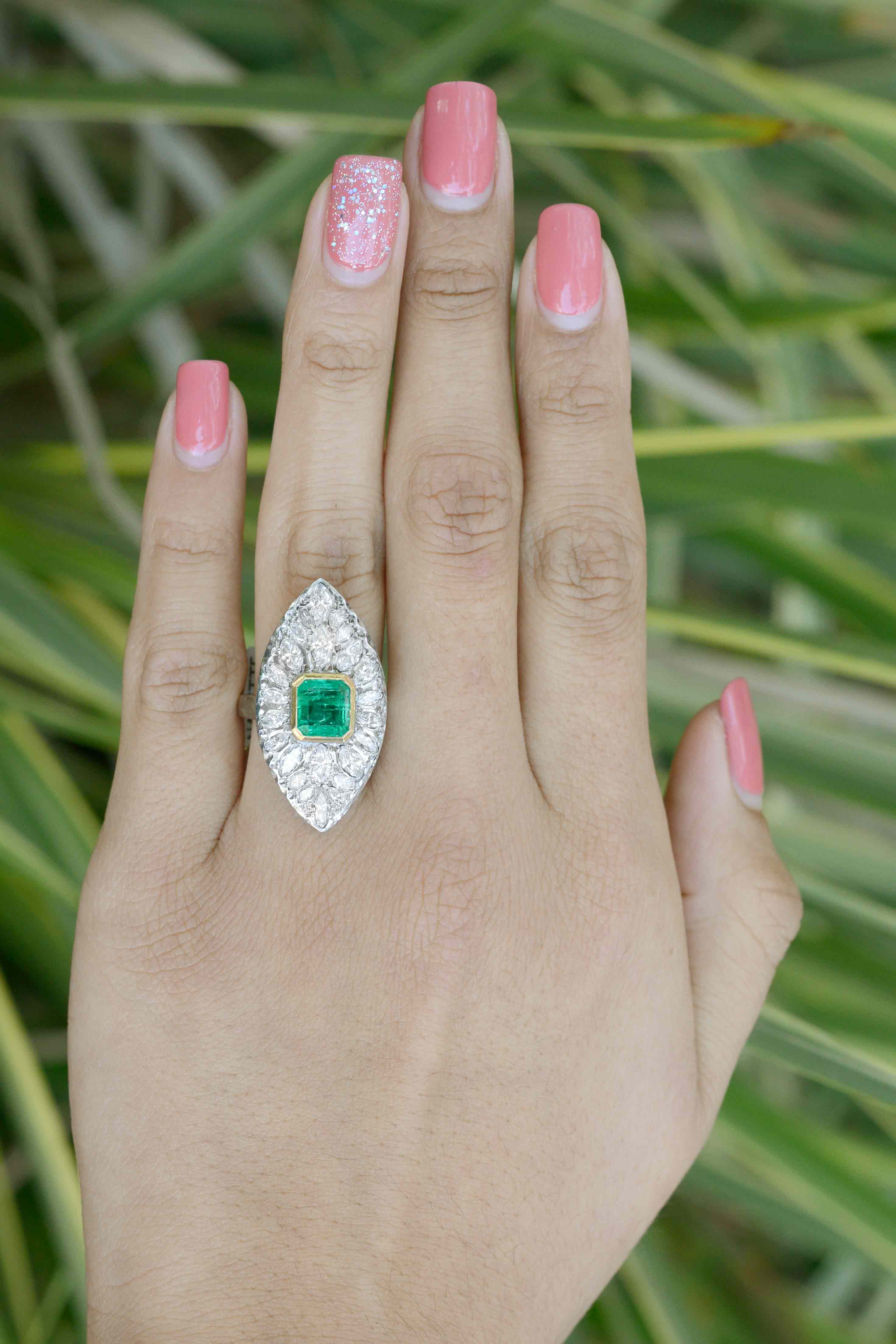 A two carat emerald and diamonds boat shaped statement ring.